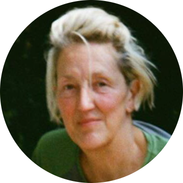 I have short messy blond/grey hair and am smiling into the camera