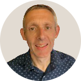 A smiling woman from Southeast Asia is wearing a light pink top and has long black hair.