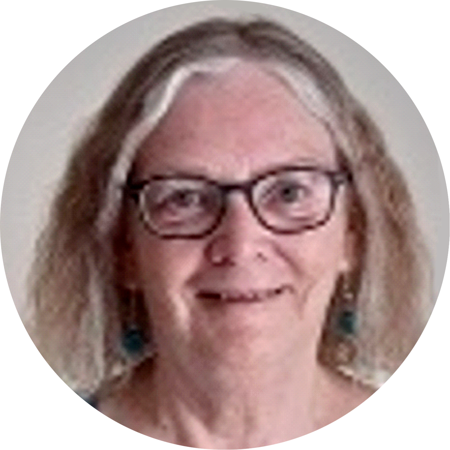 Oldish smiling lady with not-quite grey hair, wearing dark rimmed glasses.