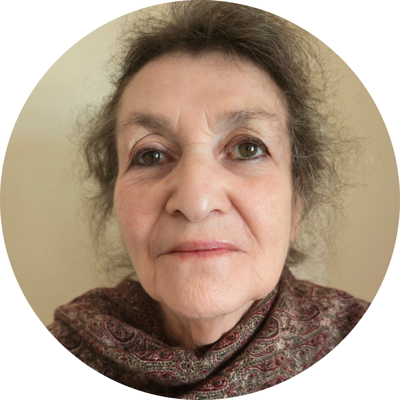 Ruth Delvin A middle-aged white woman with grey hair, glasses, and headphones, smiling in a green jumper.